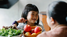 Happy asian little girl in the kitchen