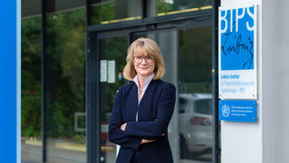 Prof. Dr. Iris Pigeot stands in front of the BIPS.