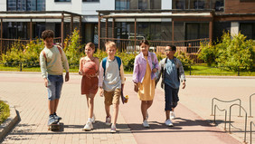 Five children walk side by side.