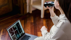 Teenager with Coke in front of their laptop