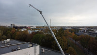 A crane lifts panels onto the BIPS roof. 