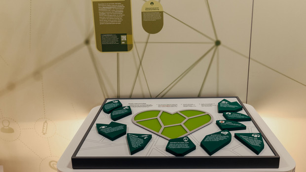 The display features a playing field with a green heart in the center and ten puzzle pieces scattered around it.