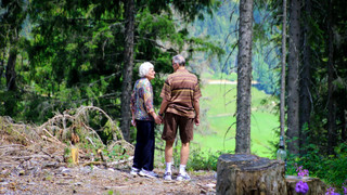 Ein altes Paar blickt in ein Tal. 