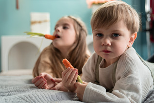 Zwei Kinder essen Karotten