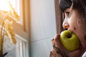 Kind isst Apfel. 