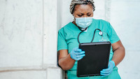 Eine Ärztin schaut auf ein Tablet.