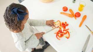 A girl chops vegetables