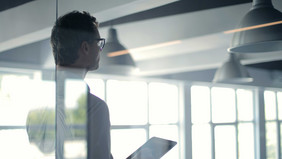 A man giving a talk behind a fogged-up glass pane.